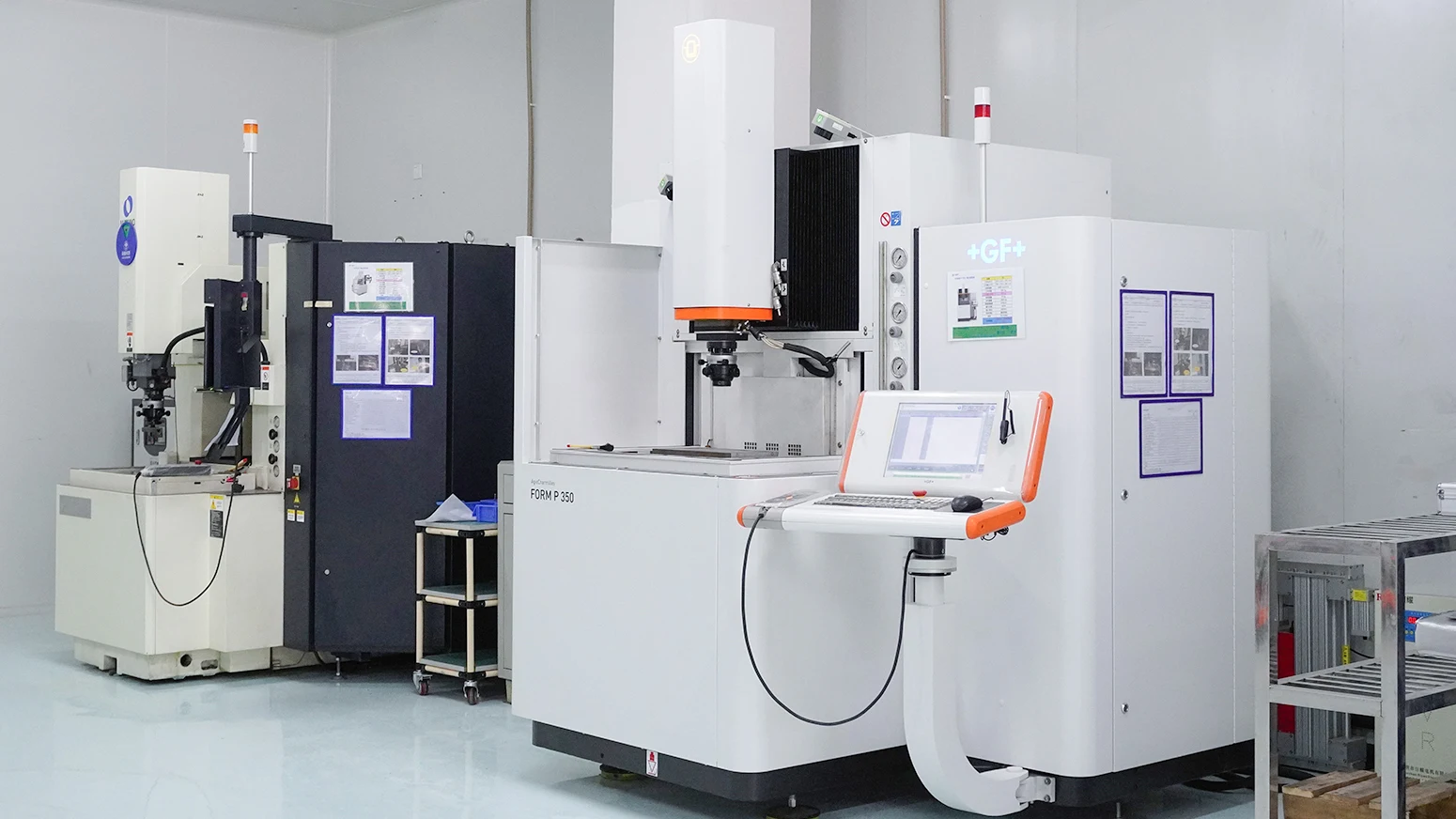 SIGGEAR official production photograph showing electrical-discharge machining equipment including a GF Form P350 machine